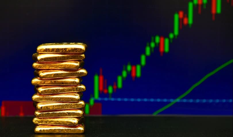 Gold bars in front of a market chart